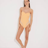 "Model wearing the Vivia Orange/Nude Molded Cup Strapless Swimsuit from the front, showcasing the geometric embroidery that contours the figure and the molded cups that offer support and a push-up effect. "