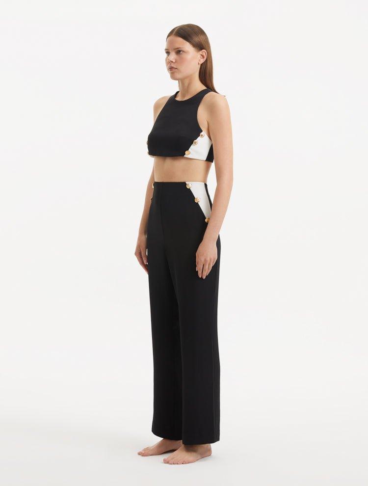 "Model presenting the Wade Black/White Pants from the side, emphasizing the flattering high-waist silhouette and the elegant flow of the fabric."