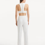 "Model presenting the Wade White/Brown Pants from the back, demonstrating the sleek high-waist silhouette and the overall tailored fit."