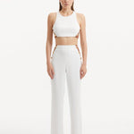 "Model showcasing the Wade White/Brown Pants from the front, highlighting the high-waist design, the contrasting white and brown colors, and the elegant shell-shaped gold buttons."