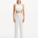 "Model showcasing the Wade White/Brown Pants from the front, highlighting the high-waist design, the contrasting white and brown colors, and the elegant shell-shaped gold buttons."