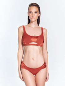 "Front view of the Willow Red Ochre Bikini Top, showcasing the scoop neckline, underbust cutout, and contrasting matte and satin fabric panel."