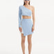 "Model wearing the Winslet White Baby Blue Crop Top and India Skirt from the front, showcasing the single shoulder and long sleeve design with shell-shaped gold accents."