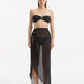 Model wearing the Xander Black Skirt from the front, highlighting the high-rise design and shell-shaped gold button details