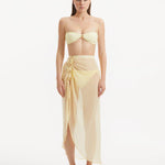 Model wearing the Xander Yellow Skort from the front, highlighting the high-rise design and shell-shaped gold button details.